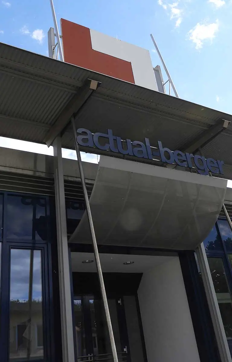 Eingangsbereich des actual-berger Firmengebäudes mit Firmenlogo und moderner Architektur.