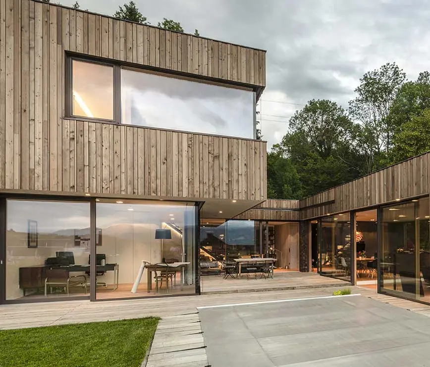 Modernes Holzhaus mit großen Glasflächen und Hebeschiebe-Türen von actual-berger.