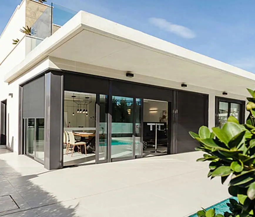 Moderner Sonnenschutz mit Außenrollos an Glasfront eines Hauses mit Terrasse