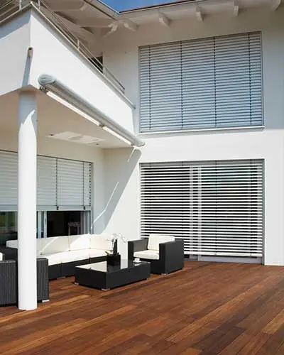 Sonnenschutz – Terrasse mit weißen Jalousien und Lounge-Möbeln