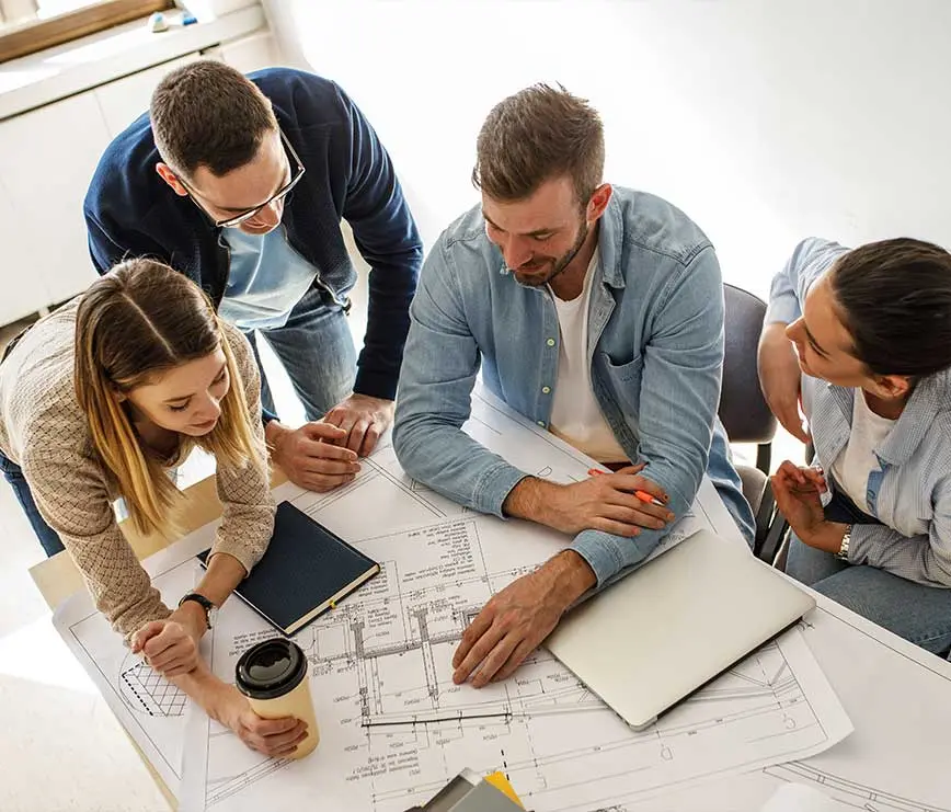 Gruppe junger Leute arbeitet gemeinsam an Bauplänen